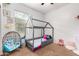 bedroom with a house-shaped bed, a wicker chair, and built-in shelving at 4908 S 244Th Ave, Buckeye, AZ 85326