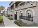 Front view of a modern townhouse with a gated entry and paved walkway at 6565 E Thomas Rd # 1141, Scottsdale, AZ 85251