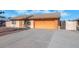 House with an orange garage door and a spacious driveway at 6730 W Vernon Ave, Phoenix, AZ 85035