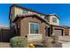 Two-story house with brown and beige exterior, large windows, and a three-car garage at 7214 W Buckhorn Trl, Peoria, AZ 85383