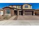 Two-story house with brown and beige exterior, large windows, and a three-car garage at 7214 W Buckhorn Trl, Peoria, AZ 85383