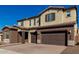 Two-story house with brown and beige exterior, large windows, and a three-car garage at 7214 W Buckhorn Trl, Peoria, AZ 85383