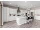 Modern kitchen with white cabinets, large island, and stainless steel appliances at 7214 W Buckhorn Trl, Peoria, AZ 85383