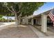 Single story home with carport, mature tree, and American flag at 7737 E Columbine Way, Mesa, AZ 85208