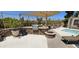 Outdoor BBQ area with stone counter, built-in grill, fire pit, and ample seating for entertaining at 7910 E Thomas Rd # 118, Scottsdale, AZ 85251