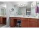 Double vanity bathroom with wood cabinets and a large mirror at 8787 E Mountain View Rd # 2101, Scottsdale, AZ 85258