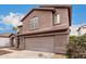 Two-story house with a brown exterior, attached garage, and landscaping at 8802 E University Dr # 66, Mesa, AZ 85207