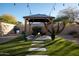 Relaxing backyard oasis with gazebo, fire pit, and artificial turf at 9439 E Palm Tree Dr, Scottsdale, AZ 85255