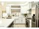 Bright kitchen featuring white cabinets, stainless steel appliances, and a farmhouse sink at 9439 E Palm Tree Dr, Scottsdale, AZ 85255