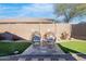 Well-manicured backyard with artificial grass, paved area, decorative chairs and block wall at 9970 E Monte Cristo Ave, Scottsdale, AZ 85260