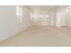 Bright and airy living room with neutral carpeting and plantation shutters at 10325 W Windsor Ave, Avondale, AZ 85392