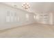 Living room with neutral carpeting, plantation shutters and chandelier at 10325 W Windsor Ave, Avondale, AZ 85392