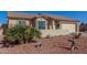 Tan house with a landscaped yard, two-car garage, and desert plants at 10334 W Sunbird Dr, Arizona City, AZ 85123