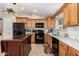 Spacious kitchen with wood cabinets, center island, and black appliances at 10334 W Sunbird Dr, Arizona City, AZ 85123