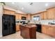 Bright kitchen with wood cabinets, island, and black appliances at 10334 W Sunbird Dr, Arizona City, AZ 85123