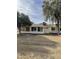 View of the home's backyard, featuring a grassy area and mature trees at 10630 W Roundelay Cir, Sun City, AZ 85351