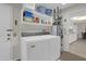 Bright laundry room, washer, dryer, and shelving for storage at 10722 W Loma Blanca Dr, Sun City, AZ 85351