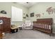 bedroom with recliner, crib, and wooden dresser at 12064 S 186Th Ave, Goodyear, AZ 85338