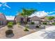 Tan house with a large tree and well-manicured lawn at 12064 S 186Th Ave, Goodyear, AZ 85338