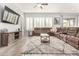 Bright living room with a brown leather sectional sofa and a large TV at 12064 S 186Th Ave, Goodyear, AZ 85338