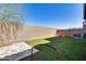 Backyard featuring a privacy wall, artificial grass, and a tiled patio area at 1255 N Arizona Ave # 1255, Chandler, AZ 85225