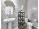 Stylish bathroom featuring a pedestal sink, decorative shelving unit, and modern fixtures at 1255 N Arizona Ave # 1255, Chandler, AZ 85225