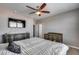 A bedroom featuring a ceiling fan, TV, wooden dresser, and a gray accent wall at 1255 N Arizona Ave # 1255, Chandler, AZ 85225