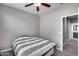 Bedroom with gray walls, ceiling fan, and a doorway leading to a bathroom at 1255 N Arizona Ave # 1255, Chandler, AZ 85225