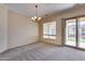 Bright dining room with chandelier, carpet flooring, and sliding door to patio at 12629 W Bajada Rd, Peoria, AZ 85383