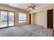 Living room with built-in shelving, sliding door to patio, and ceiling fan at 12629 W Bajada Rd, Peoria, AZ 85383