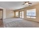 Bright living room with carpet flooring, sliding glass doors, and a ceiling fan at 12629 W Bajada Rd, Peoria, AZ 85383