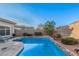 Inviting swimming pool with stone coping and landscaping at 14836 W Desert Hills Dr, Surprise, AZ 85379