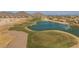 Aerial view of a golf course with a lake and residential homes in the background at 169 E Canary Ct, San Tan Valley, AZ 85143