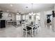 Bright dining area with white table and chairs, adjacent to living room at 17563 W Fairview St, Goodyear, AZ 85338