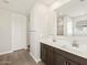 Bathroom featuring double vanity with white countertops and dark wood cabinets at 17761 W Elm St, Goodyear, AZ 85395