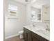 Bright bathroom featuring double sinks, dark wood cabinetry and tile floors at 17761 W Elm St, Goodyear, AZ 85395