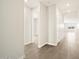 Light and airy hallway featuring wood-look tile, leading to the living area and bedrooms at 17761 W Elm St, Goodyear, AZ 85395