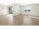 Bright living room with wood-style tile flooring, sliding glass doors, and modern chandelier at 17761 W Elm St, Goodyear, AZ 85395