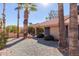 Desert landscaping with gravel, mature palm trees, and a patio area at 19633 N Marble Dr, Sun City West, AZ 85375