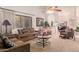 Cozy living room with brown couches, a coffee table, and a ceiling fan at 19633 N Marble Dr, Sun City West, AZ 85375