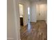 Inviting hallway with wood-look tile flooring and neutral paint, leading to various rooms in the home at 20612 N 226Th Dr, Surprise, AZ 85387