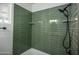 Updated bathroom with green tile shower and built in shelves at 2112 W Mulberry Dr, Phoenix, AZ 85015