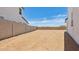 View of the dirt lot backyard with a block wall and a house on either side at 2316 W Moody Trl, Phoenix, AZ 85041