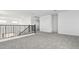 Spacious upstairs loft with neutral carpet and black metal banister at 2316 W Moody Trl, Phoenix, AZ 85041