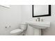 White pedestal sink and toilet in a minimalist powder room at 2316 W Moody Trl, Phoenix, AZ 85041