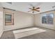 Carpeted bedroom with ceiling fan and large window at 2327 W Branham Ln, Phoenix, AZ 85041