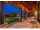 Stone patio with covered walkway, pool, and putting green views at 23414 N 84Th Pl, Scottsdale, AZ 85255