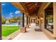 Covered patio overlooks a pool, putting green, and desert landscaping at 23414 N 84Th Pl, Scottsdale, AZ 85255