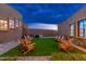 Relaxing backyard patio with artificial turf and wooden chairs at 23414 N 84Th Pl, Scottsdale, AZ 85255