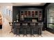 Dark wood home bar with a granite countertop and glass-front cabinets at 23414 N 84Th Pl, Scottsdale, AZ 85255